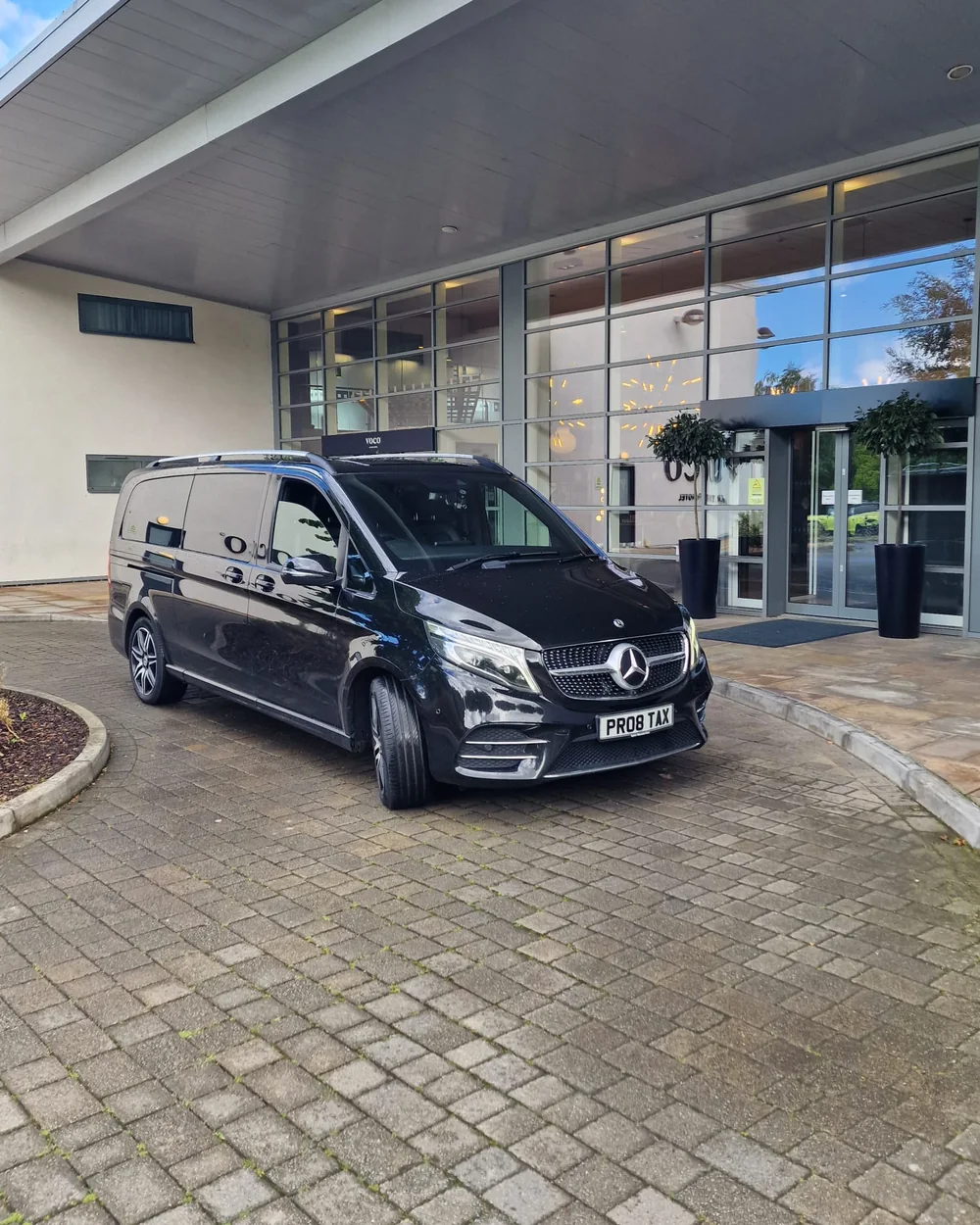 Proline black Mercedes-Benz V-Class waiting at a hotel entrance for a private chauffeur transfer in Bristol